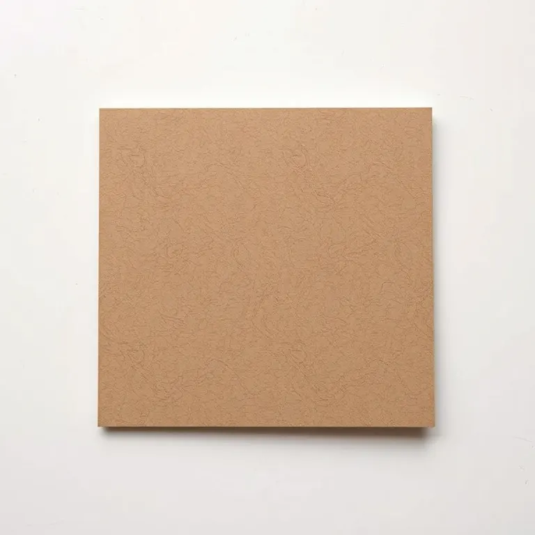 A warm grey-brown hard card on a pale bench with one corner lifted to show the thickness of the board.
